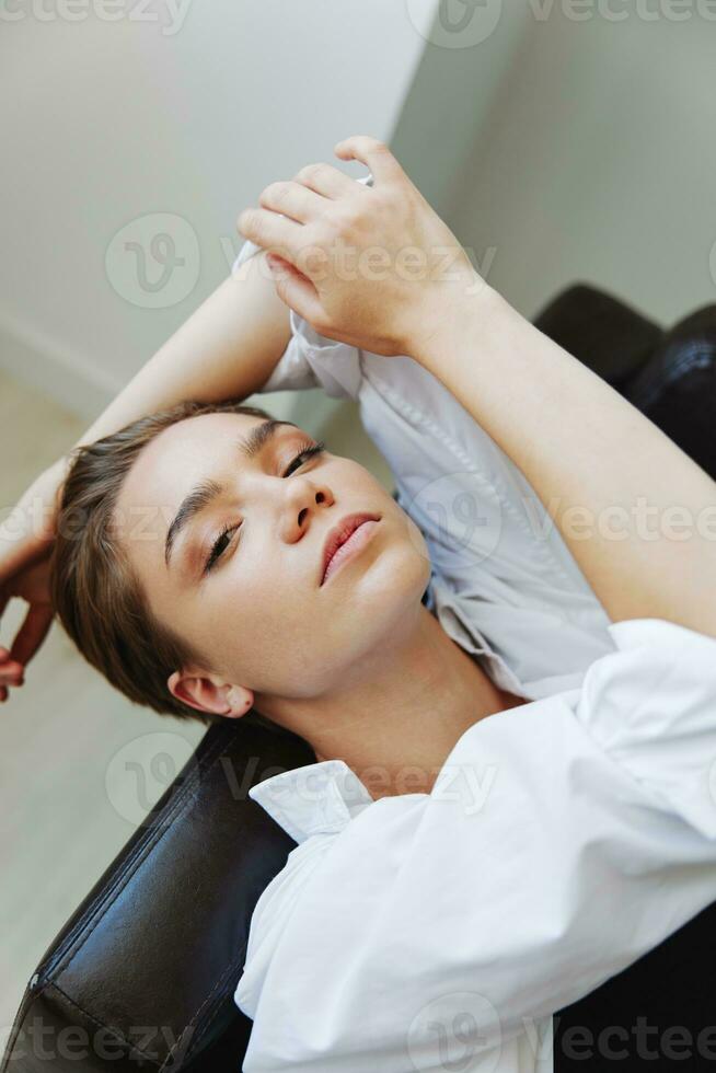 mulheres deitado às casa em a sofá retrato com uma curto corte de cabelo  dentro uma branco camisa, sorriso, depressão dentro adolescentes, casa  feriado 23692124 Foto de stock no Vecteezy